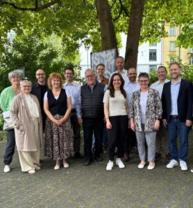 Mitglieder des Abstimmungskomitees am Abstimmungssonntag im Neubad Luzern. Gruppenfoto unter Bäumen. Mitglieder freuen sich und lächeln.