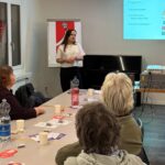 Foto mit Anja Meier als Rednerin und mehrere Zuhörer*innen